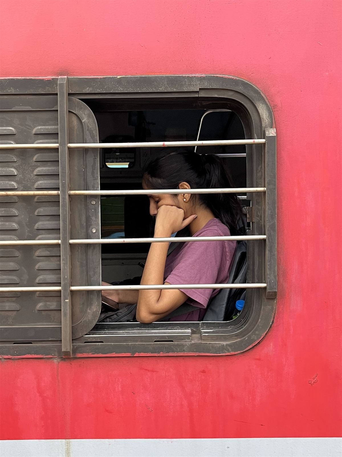Passenger looking out of a red train window