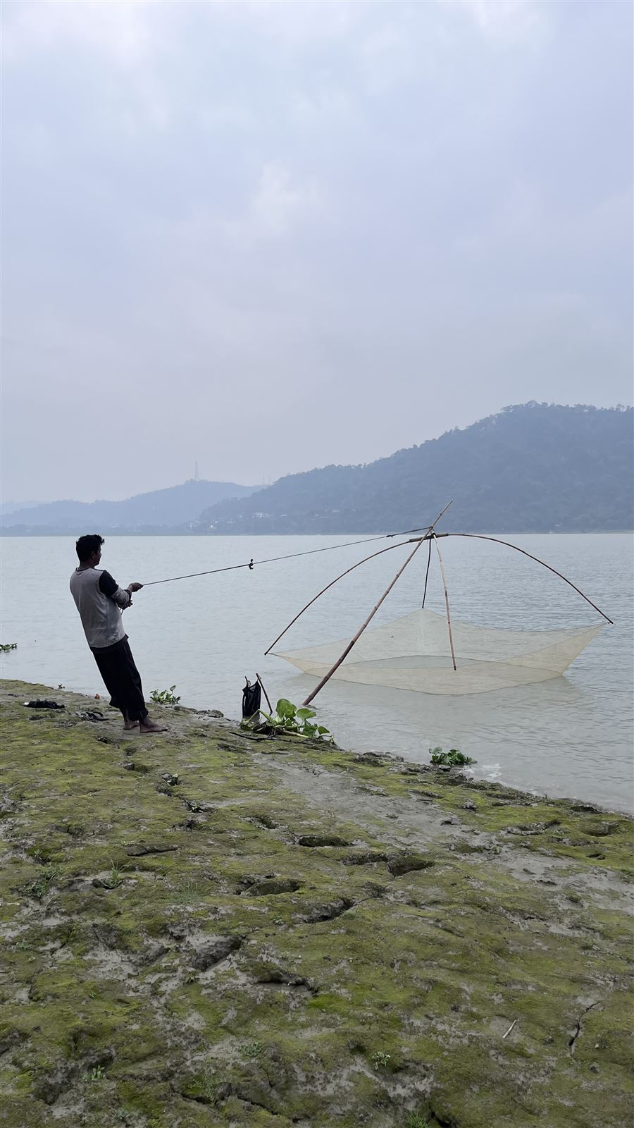 Fisherman with a lift net on the riverbank